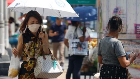 Una tailandesa usa mascarilla por el aumento de casos de covid-19 en su país.