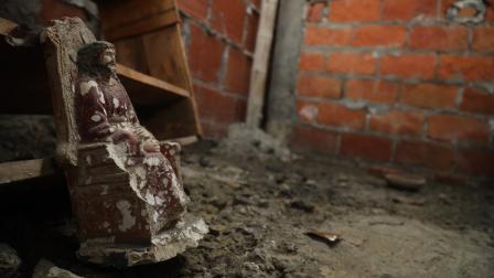 Figura de un Cristo hallada junto a sangre seca, una vasija de barro y diversos materiales en el suelo de una vivienda vacía, allanada por el Bloque de Seguridad en Fincas Delia, al sureste de Durán, el 23 de julio de 2024.