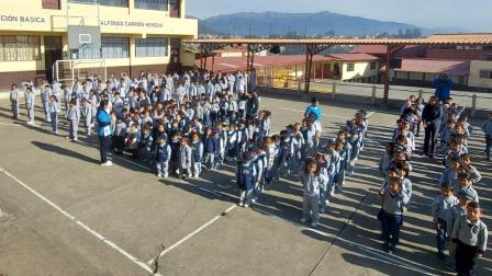 Estudiantes formados en el patio de una escuela de Cuenca.