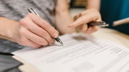 Fotografía referencial de una persona que revisa los detalles de un contrato para adquirir un seguro de vida.