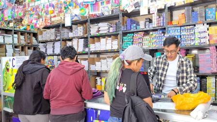 Padres de familia buscan útiles y libros escolares en una librería en el centro histórico de Quito, en agosto de 2026.