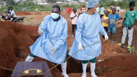 Personas con equipo protector sepultan a un fallecido por la enfermedad del virus del ébola en Bunia, RD Congo, el 18 de agosto de 2026.