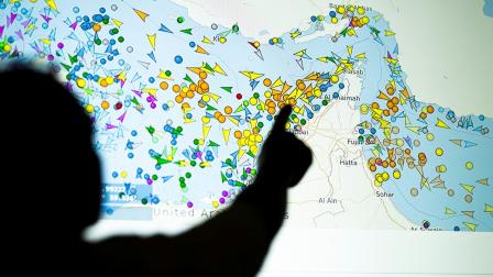 Una fotografía tomada en Nicosia el 4 de mayo de 2026 muestra a una persona frente a una gran pantalla donde se ve el movimiento de buques en el estrecho de Ormuz en un sitio web de seguimiento de barcos.