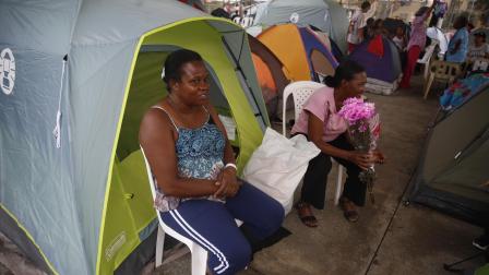 Personas permanecen en carpas frente a edificios dañados por el terremoto en Cali, Colombia, el 17 de agosto de 2026.