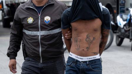 Imagen referencial de un agente de la Policía Nacional de Ecuador escoltando a un presunto miembro de la banda criminal "Los Lobos", capturado durante un operativo tras un ataque un puesto policial en Guayaquil.