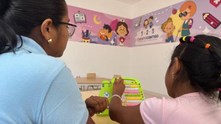 Archivo. Una profesional ayuda a una niña durante un proceso pedagógico en un aula en un establecimiento de Guayaquil.