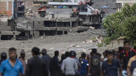 Personas observan las inundaciones en el Bazar Trishuli en Nepal el 26 de agosto de 2026.