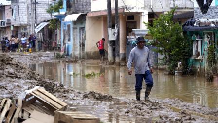 Personas caminan en medio de las calles llenas de lodo en Balao, Guayas, tras las fuertes lluvias del 11 de marzo de 2026.