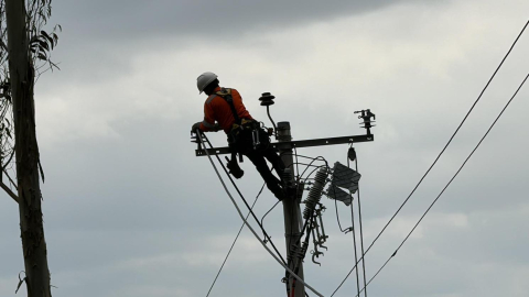 Un obrero de la Empresa Eléctrica Quito realiza trabajos en un poste de alumbrado público, el 9 de agosto de 2024.