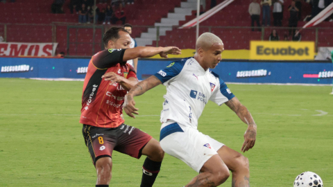 Deyverson, de Liga de Quito, defiende el balón ante la marca de Édison Vega, de Deportivo Cuenca, en el partido jugado el sábado 12 de septiembre de 2026.