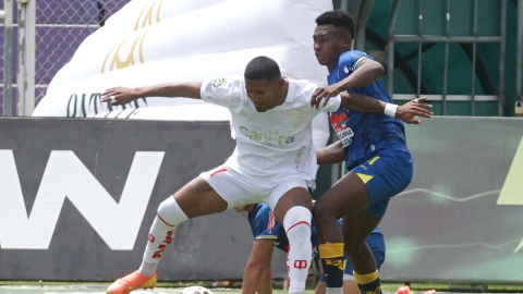 Luis Estupiñán, de Técnico Universitario, controla el esférico ante un jugador de Delfín, en el partido del 20 de septiembre de 2026, en Ambato.