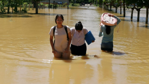 Habitantes del cantón Balao caminan en medio del agua, tras el desbordamiento que llega el mismo nombre, el 28 de septiembre de 2026.