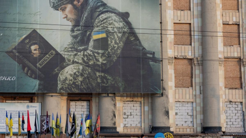 Varias personas pasan junto a un mural de un soldado ucraniano en la ciudad de Járkov, en medio de la guerra con Rusia, el 20 de octubre de 2026.