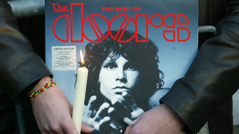 Un fan sostiene un lp de The Doors, ante la tumba de Jim Morrison, en el cementerio Père Lachaise en París, Francia.