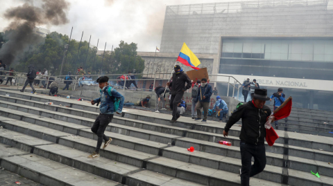 Manifestantes escapan del gas lacrimógeno empleado para desalojarlos.