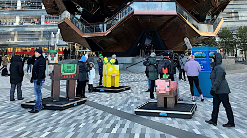 Asistentes a la presentación de 'Minecraft Earth' observan estatuas de personajes del videojuego junto a la escultura 'The Vessel' el 16 de noviembre de 2019, en Nueva York (Estados Unidos).