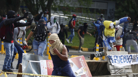 Grupos de manifestantes se enfrentan a la policía durante el paro nacional de Colombia.