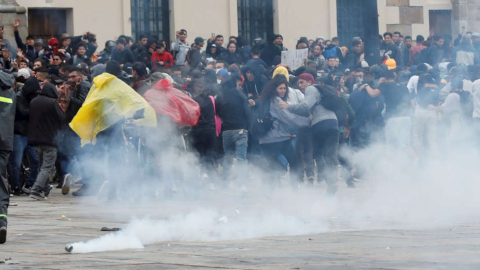 Miembros de las fuerzas del orden dispersan con gases a manifestantes durante un cacerolazo este viernes, en la Plaza Bolívar de Bogotá.