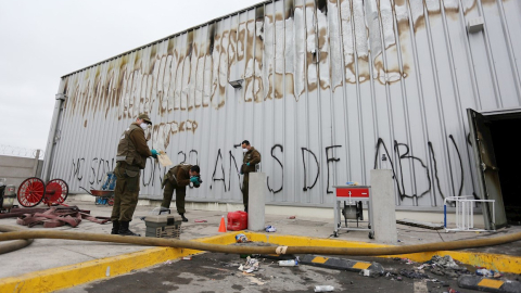 Peritos policiales realizan pesquisas en un local de la cadena Walmart, que resultó quemado y saqueado.