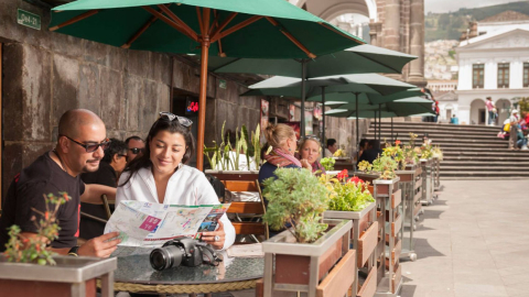 Una pareja de turistas ve un mapa en una de las cafeterías ubicadas en la Plaza de La Independencia, en el Centro Histórico de Quito. 