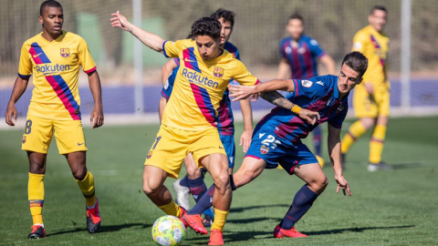 Kike Saverio cuida muy bien la pelota tras la marca de los defensas de Levante.