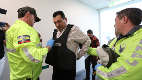 El exsecretario de Inteligencia, Pablo Romero, camina por uno de los pasillos del Aeropuerto Mariscal Sucre junto a dos policías, el 21 de febrero.