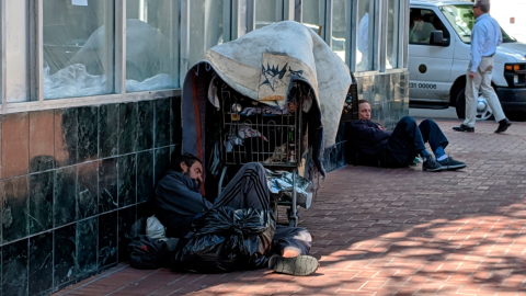 Aparecen dos sintecho acostados junto a sus pertenencias en una calle del barrio del Tenderloin en San Francisco, California. 