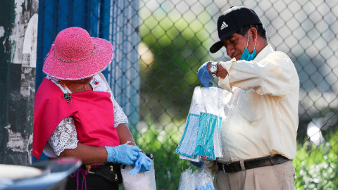 En las calles de Quito, los ciudadanos adquieren mascarillas a vendedores ambulantes, el 21 de marzo de 2020.