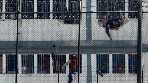 Reclusos se asoman en ventanas este domingo luego de un motín, en cárcel la Modelo de Bogotá.