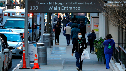 Persona caminando con mascarillas por la entrada del Hospital Lenox Hill en Nueva York, el 26 de marzo.