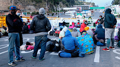 Fotografía cedida por la Prefectura de Carchi ciudadanos venezolanos descansando en el lado ecuatoriano del puente Rumichaca que separa a Ecuador de Colombia, el 29 de abril de 2020.