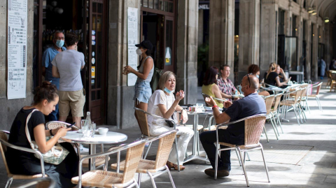 Varios clientes toman sus bebidas en una terraza de la Plaza Real de Barcelona, 25 de mayo de 2020.