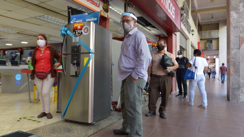 Ciudadanos esperan afuera de una tienda en el centro de Guayaquil, el pasado 20 de mayo. 