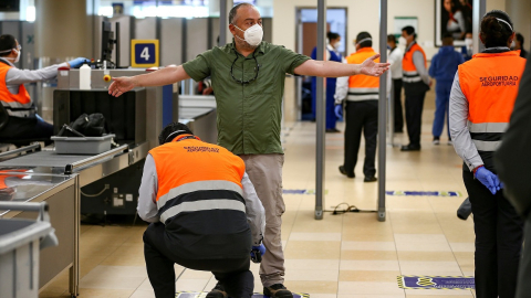 Trabajadoras del aeropuerto de Quito revisan a un pasajero, tras la reanudación de operaciones, el 1 de junio. 