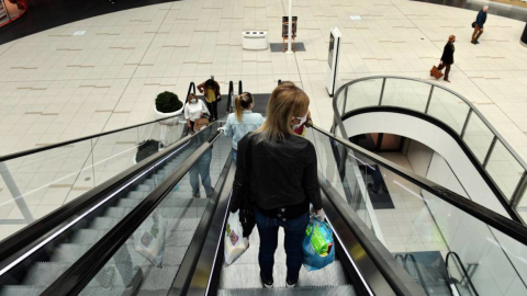 Personas en las escaleras eléctricas de un centro comercial en la ciudad de Bogotá, Colombia.