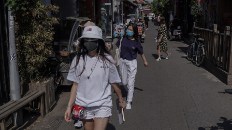 Ciudadanos portando mascarillas caminan por una calle en China, país que detectó dos nuevos casos de Covid-19, el 12 de junio. 