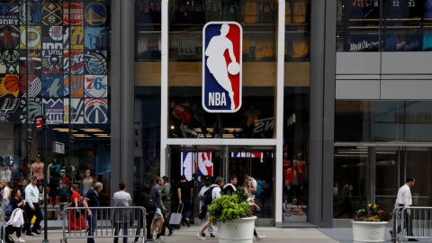 Ciudadanos caminan por los exteriores de una tienda de la NBA en Nueva York, Estados Unidos, el 14 de junio de 2020.