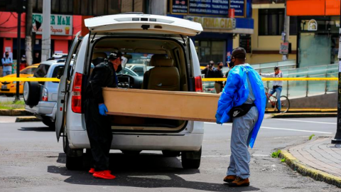 Trabajadores de una funeraria transportan un ataúd en Quito, el pasado 14 de mayo de 2020.