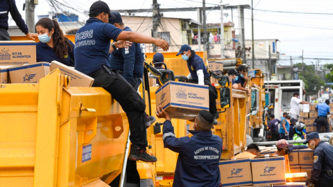 Guardias metropolitanos y efectivos de la Armada colaboran en la entrega de kits de alimentos del Municipio de Guayaquil, el 29 de julio de 2020. 