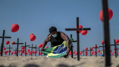 Imagen referencial. Una activista instala una bandera de Brasil en un acto por los 100.000 fallecidos de Covid-19, realizado en la playa de Copacabana, el 8 de agosto de 2020.