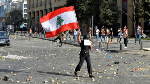 Una manifestante sostiene una bandera de Líbano afuera del Parlamento, el 8 de agosto de 2020.