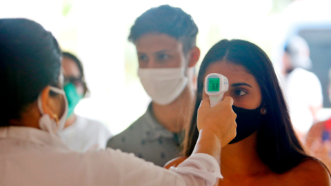 Una trabajadora de la salud toma la temperatura a los visitantes en el Hotel Meliá Sol Palmeras de Varadero (Cuba).