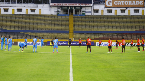 Jugadores de Católica y Aucas guardan un minuto de silencio en el partido del domingo 16 de agosto de 2020, en Quito.