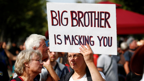 A woman holds a sign during a rally against the government's restrictions following the coronavirus disease (COVID-19) outbreak, in Berlin, Germany August 29, 2020. REUTERS/Axel Schmidt