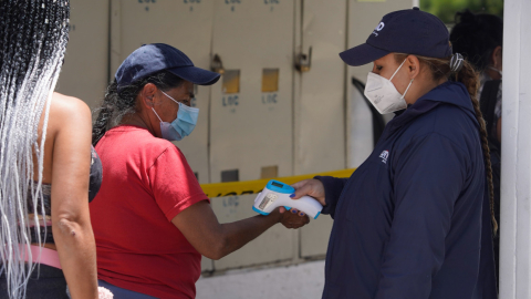 Una persona toma la temperatura a quienes ingresan al Terminal Terrestre de Carcelén, en Quito, el 2 de septiembre de 2020. 