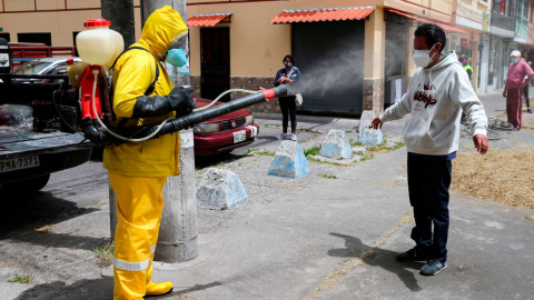 Personal sanitario de Quito desinfecta a un hombre, el 20 de agosto de 2020.