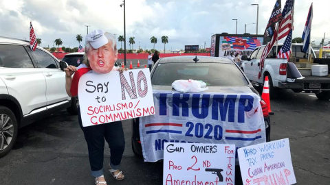 Unas personas sostienen carteles a favor del presidente Donald Trump mientras participan una manifestación multitudinaria contra el comunismo el 10 de octubre de 2020, en Miami, Florida (EEUU).