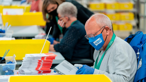 Un operario apila papeletas en de las elecciones en Renton, Washington, el  3 de noviembre de 2020.