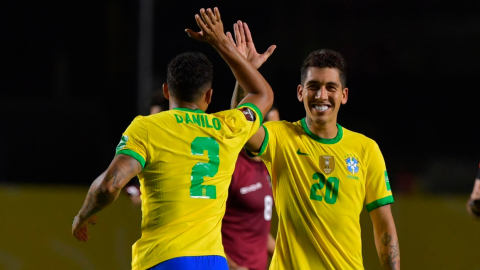 Roberto Firmino celebra junto a Danilo el 1-0 de Brasil frente a Venezuela en la fecha tres de Eliminatorias a Catar 2022.