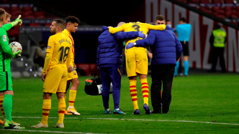 El defensa del FC Barcelona, Gerard Piqué, se retira lesionado del terreno de juego tras una jugada.